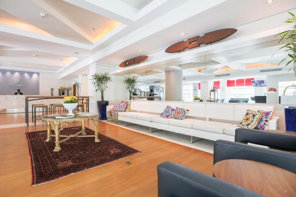 库里提巴库里提巴佩斯塔纳酒店的客厅配有白色的沙发和桌子