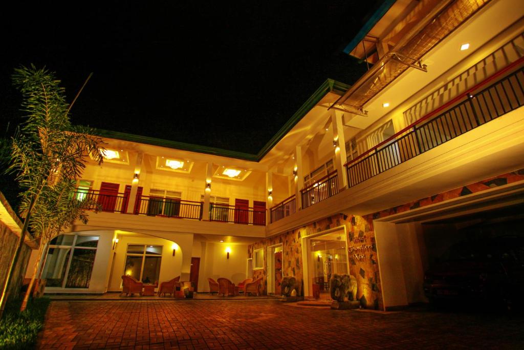 康提Hotel Travellers Nest Kandy的一座在晚上设有庭院的大建筑