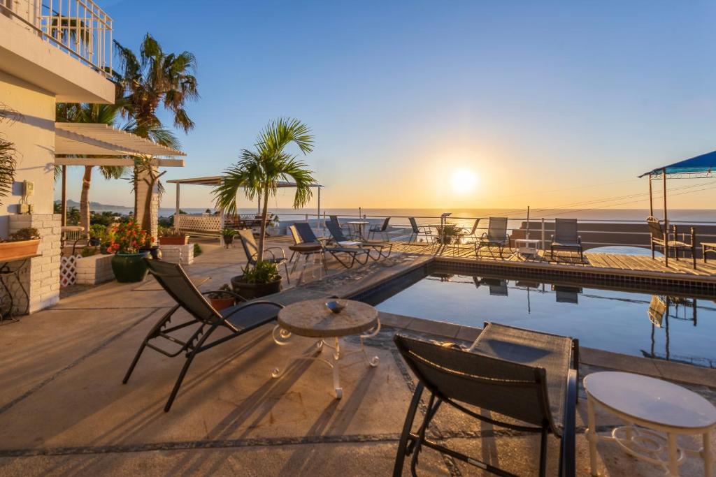 圣何塞德尔卡沃玛利亚马尔套房酒店的一个带椅子的庭院、一个游泳池和大海