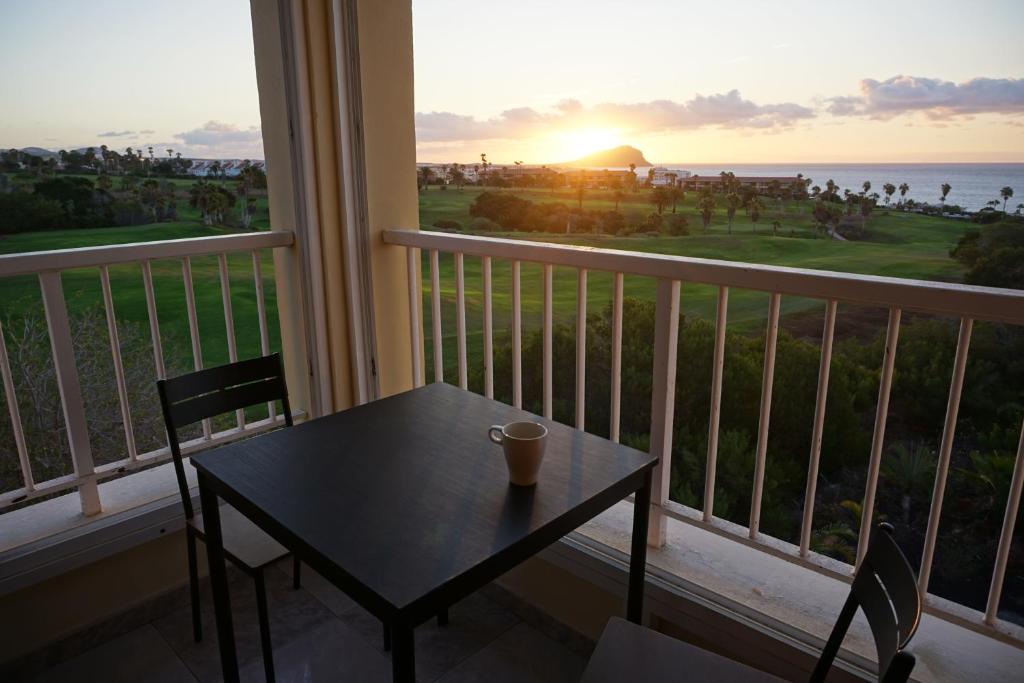 圣米格尔德阿沃纳Golf del Sur Apartment - magnificent panorama of the ocean, el Teide, and Montaña Roja的海景阳台上的桌椅
