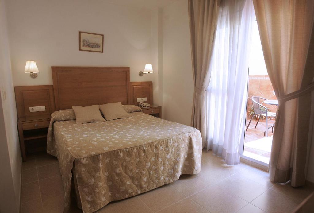 马拉加戈阿廷酒店的一间卧室设有一张床和一个大窗户