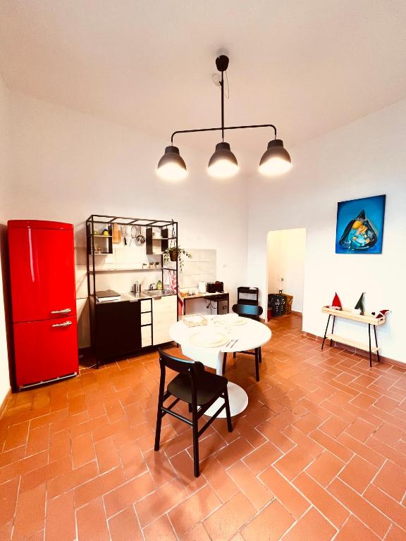 佛罗伦萨CasAmalia的厨房配有桌子和红色冰箱