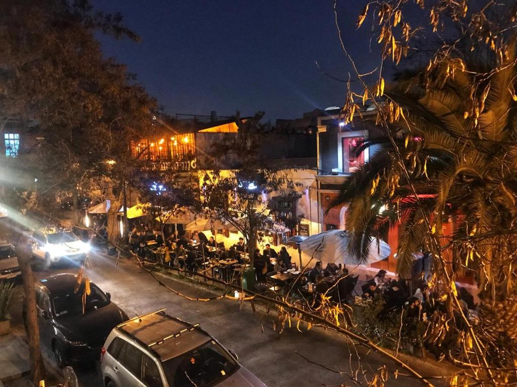 圣地亚哥Wild Bellavista Hostel的繁忙的城市街道,晚上停有车辆