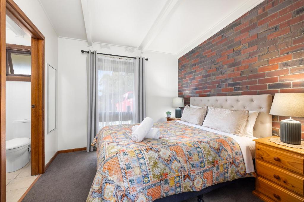 霍尔斯加普Halls Haven Holiday Units的一间卧室设有一张床和砖墙