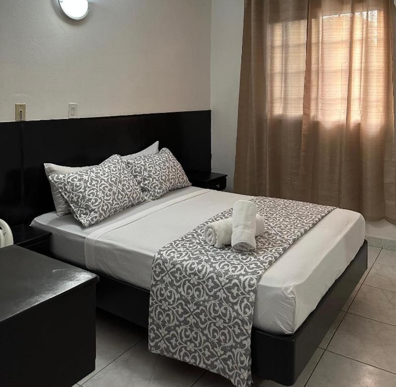 巴拿马城HOTEL BLUE COSTA Panama的一间卧室配有一张带枕头的大床