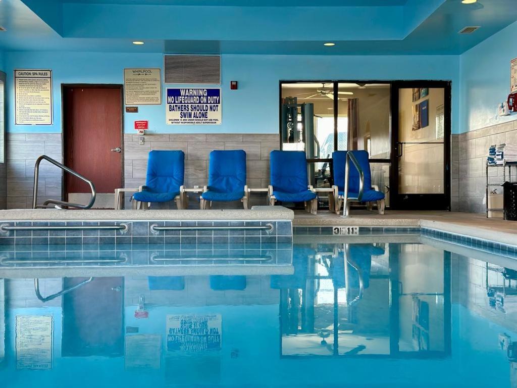 奥格登Comfort Inn Ogden near Event Center的游泳池旁设有蓝色椅子