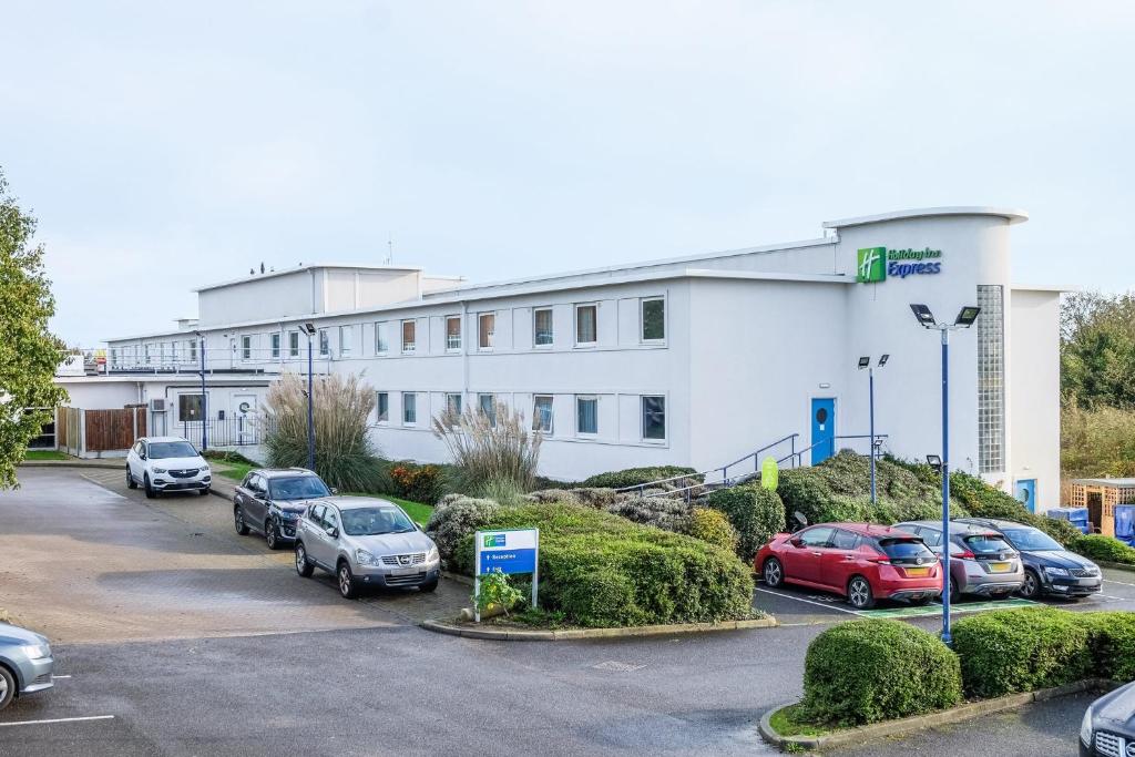 明斯特Holiday Inn Express Ramsgate – Minster, an IHG Hotel的一座白色的大建筑,汽车停在停车场