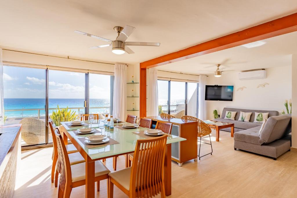 坎昆Amazing Caribbean Ocean view at Villas Marlin in Cancun的用餐室以及带桌椅的起居室。