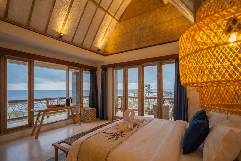 BatununggulALANA PENIDA HOTEL的一间卧室设有一张床,享有海景