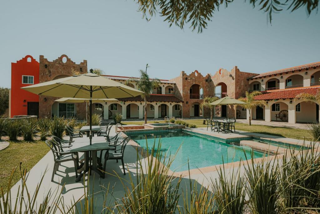 Rancho GrandeHacienda Los Olivos, Valle de Guadalupe的一个带游泳池和桌椅的度假酒店