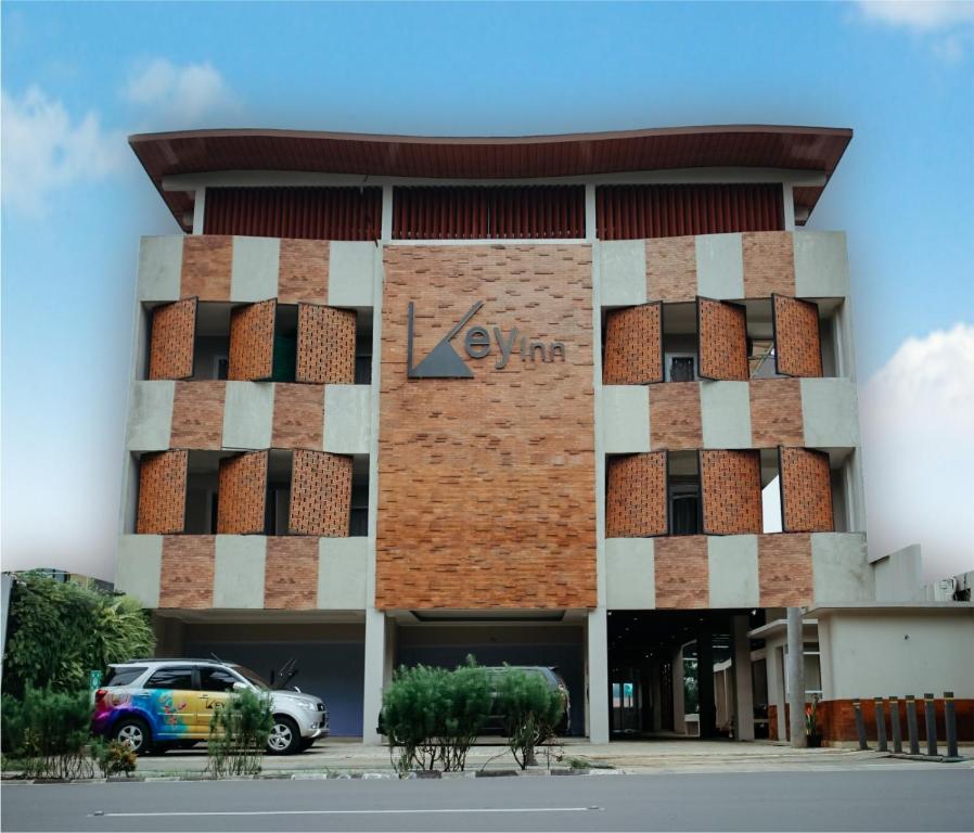 KamparganyaKey Inn Hotel Bogor的前面有停车位的建筑
