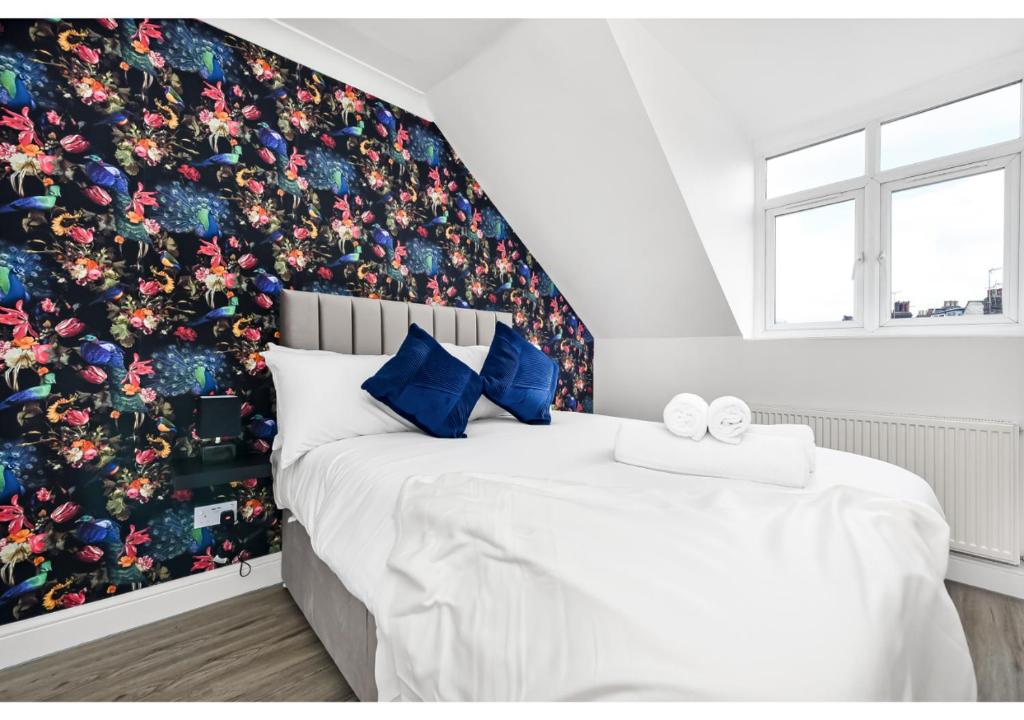 伦敦Awesome Loft Flat - Seconds to London’s Best Park!的一间卧室配有一张带花卉壁纸的大床