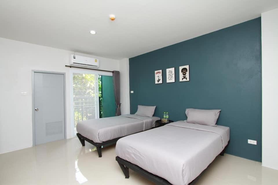 黎府Around Loei的一间卧室设有两张床和蓝色的墙壁