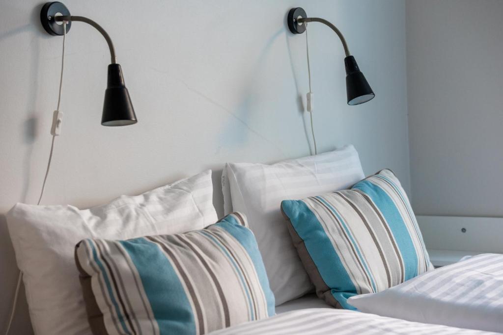 内斯考塔杜尔希尔迪布兰德公寓酒店的床上方的两盏灯和白色枕头