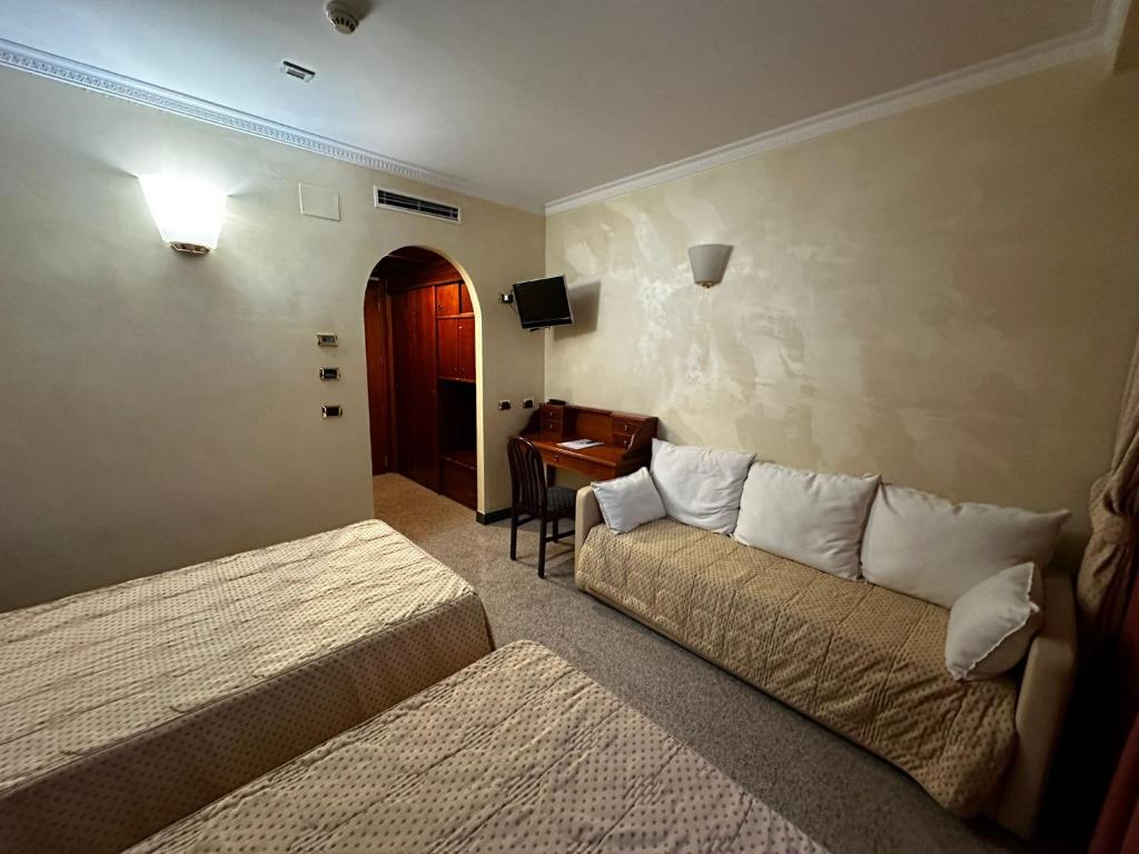 伊塞尔尼亚欧洲大酒店的客房设有两张床、一张沙发和一张书桌。