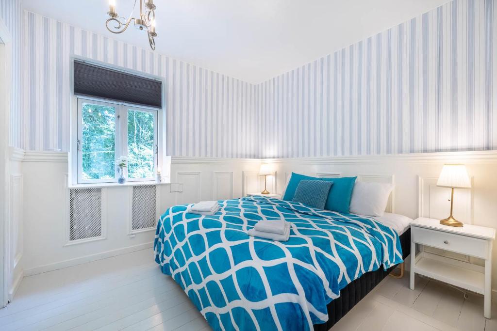 BryrupVelling Koller Hotel og Camping的卧室配有蓝色和白色的床和窗户。
