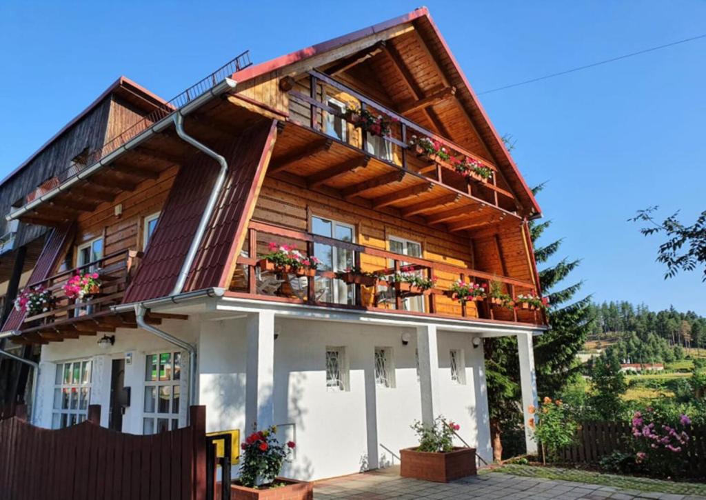 卡尔帕奇Dom na Karkonoskiej的带阳台和鲜花的木屋