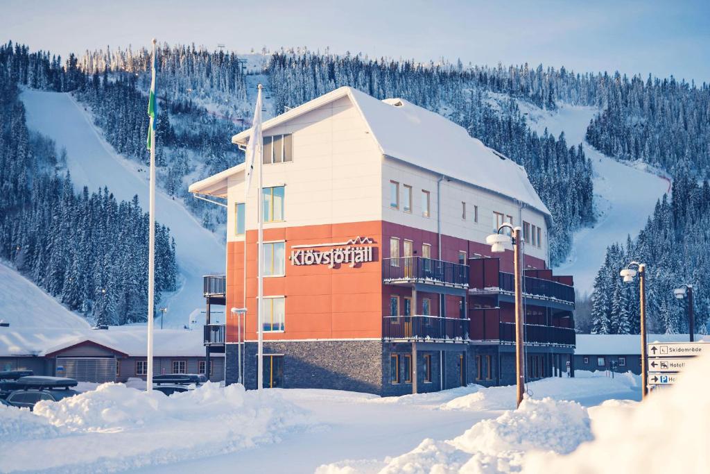 KlövsjöHotell Klövsjöfjäll的一座雪中与山间的建筑