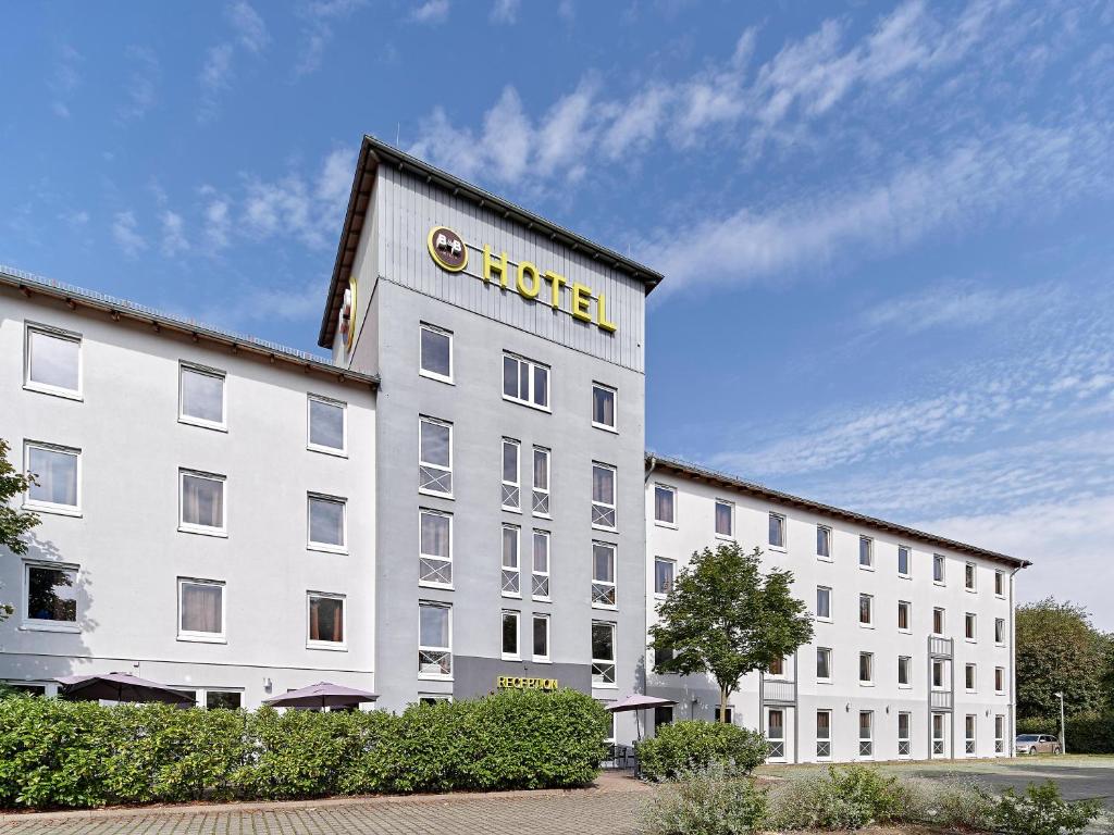 科隆B&B Hotel Köln-West的一座白色的大建筑,上面有酒店标志