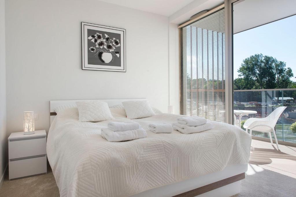 波别罗沃Apartament Premium PINEA 102的白色的卧室设有床和大窗户