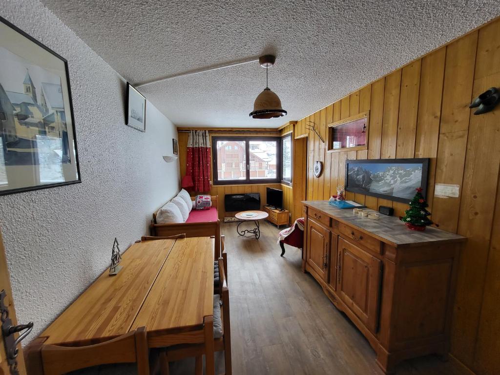 圣沙夫雷Les Mélèzes的客厅配有木桌和电视。