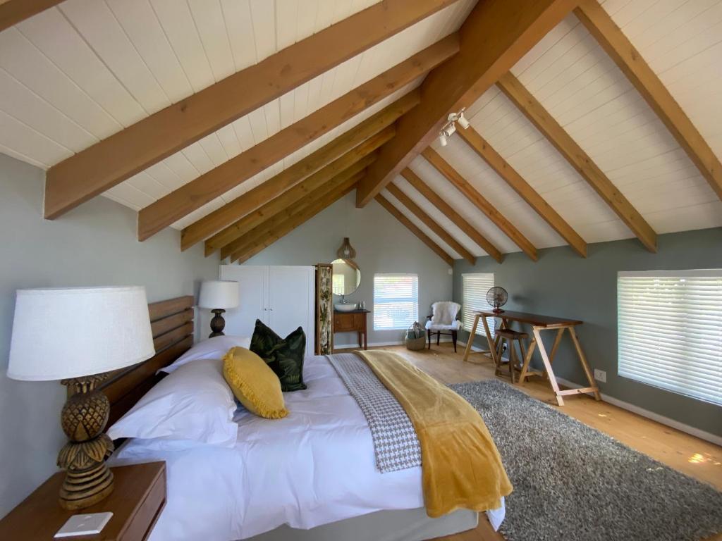 贝尔维尔The Vine的一间卧室配有白色床单和木制天花板。