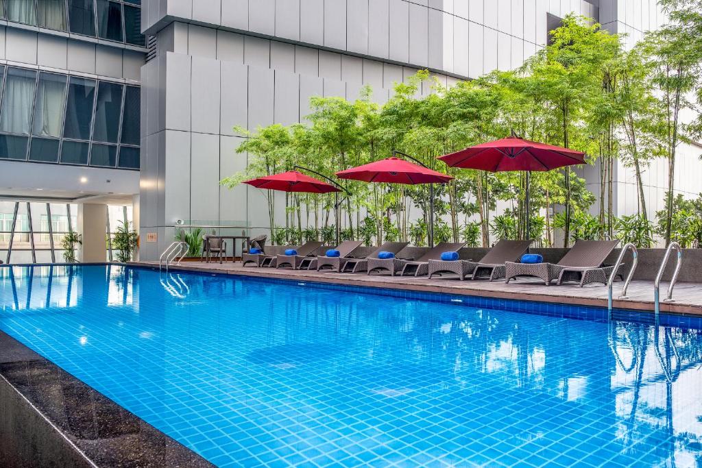 吉隆坡吉隆坡雅诗阁中心酒店的一个带椅子和遮阳伞的游泳池