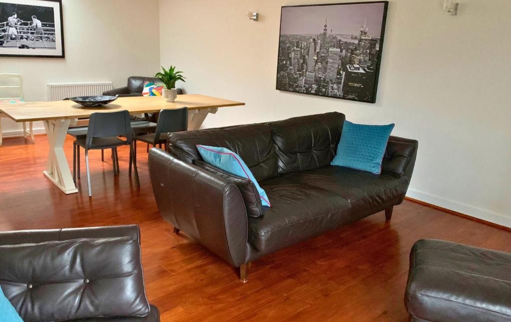 沃金厄姆Wokingham - Large 2 bedroom Apartment的客厅配有真皮沙发和桌子