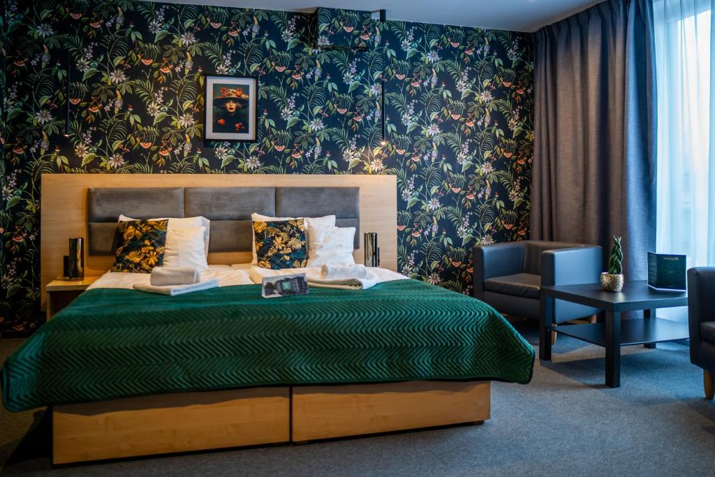比托姆Seven Hotel Bytom - Katowice的一间卧室配有一张带绿色棉被的床