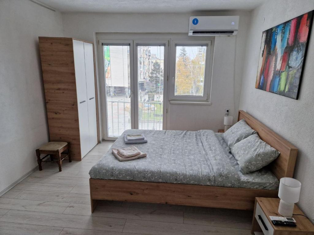 库马诺沃City Square Apartment的一间卧室设有一张床和一个大窗户