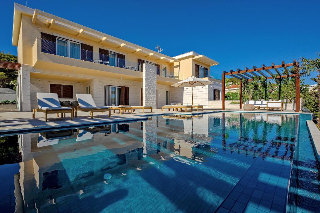 赫瓦尔Immensely Luxurious Hvar Villa - 5 Bedrooms - Villa East Eternal - Exceptional Sea Views and Private Pool的别墅前设有游泳池