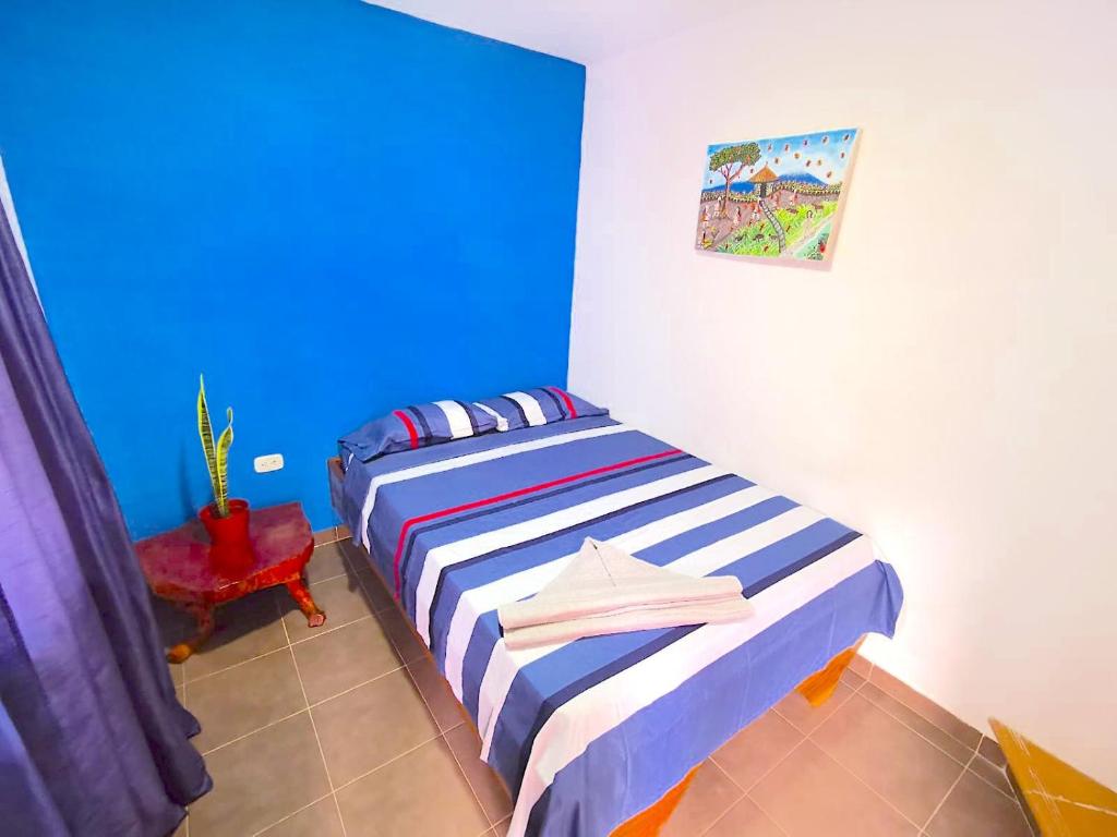 米卡Central Habitación en Minca的一间卧室配有一张蓝色墙壁的床