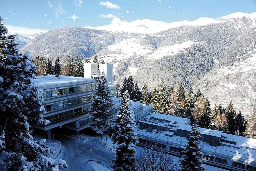 马里尔伊瓦Appartamento Marilleva1400 residence Albarè的一座白雪覆盖的山顶上的建筑