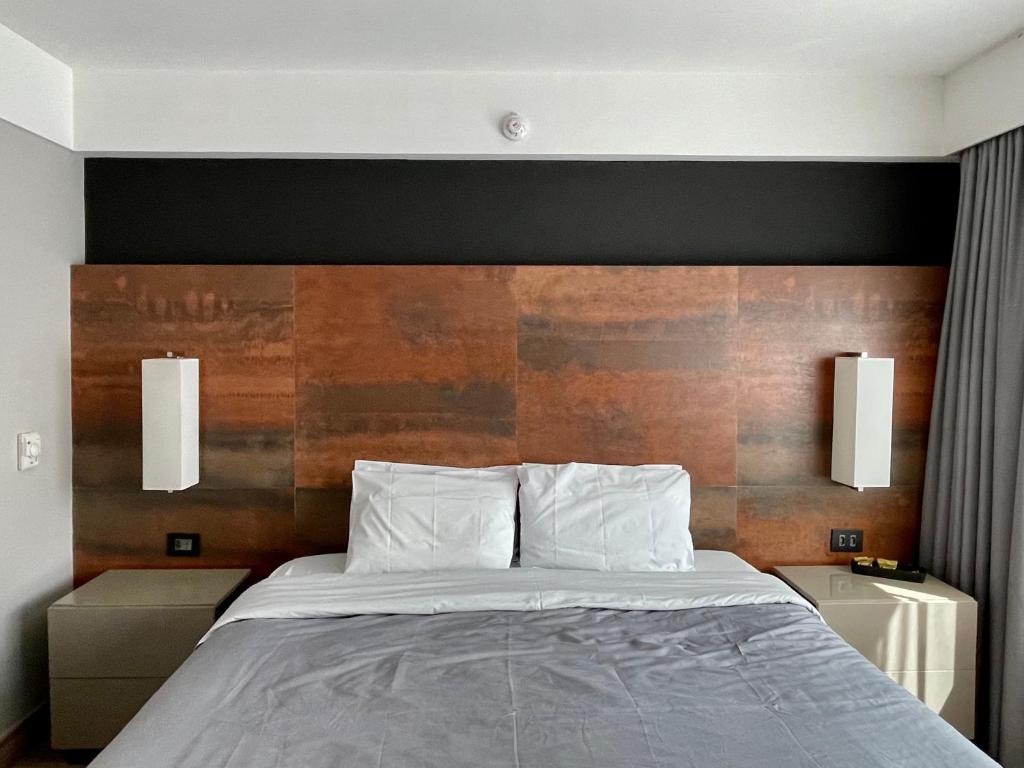 圣保罗Flat particular incrível dentro do hotel M Ibirapuera em Moema的一间卧室配有一张带木制床头板的床