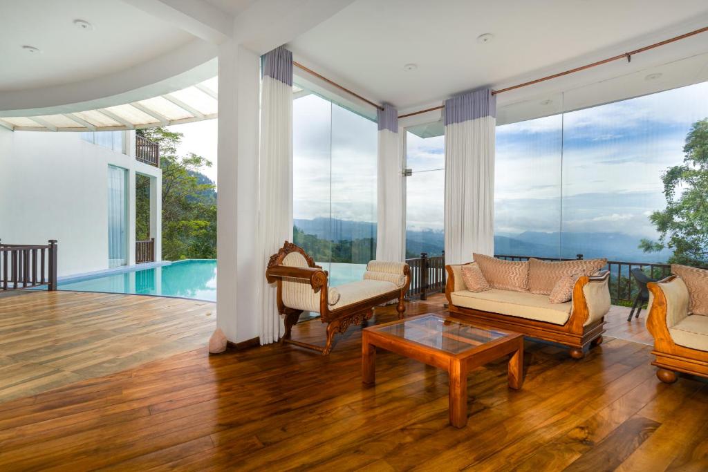 康提Villa Vajrapani的客厅铺有木地板,设有玻璃窗。