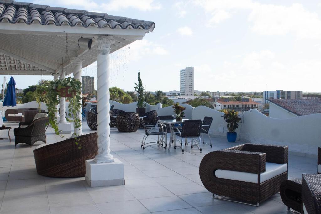 保利斯塔New Casablanca Praia Hotel的屋顶上带桌椅的天井