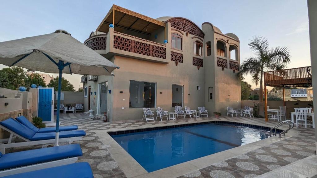 卢克索Yasmine Guest House的一座带游泳池和房子的别墅