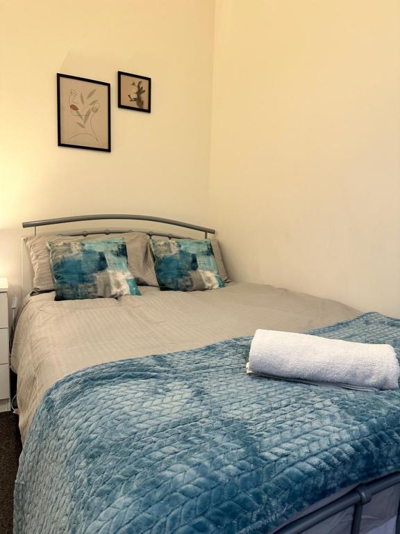 ParksideLovely Town house Room 1的一间卧室配有一张带蓝色棉被的床