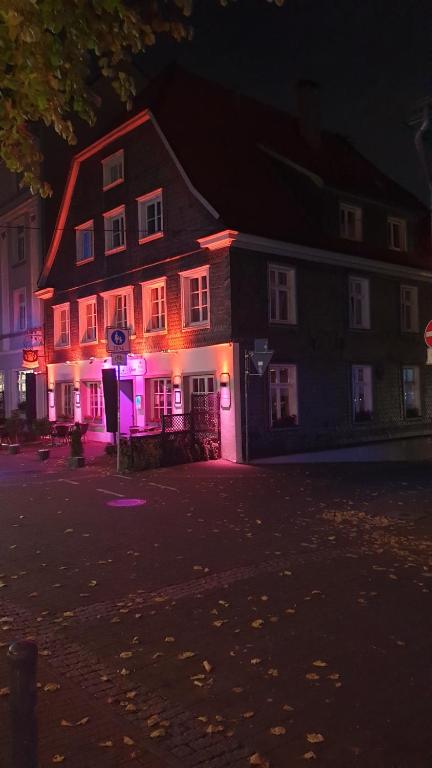 雷克林豪森Hotel Restaurant Meints4you im Bürgerhof的建筑前方有紫色灯