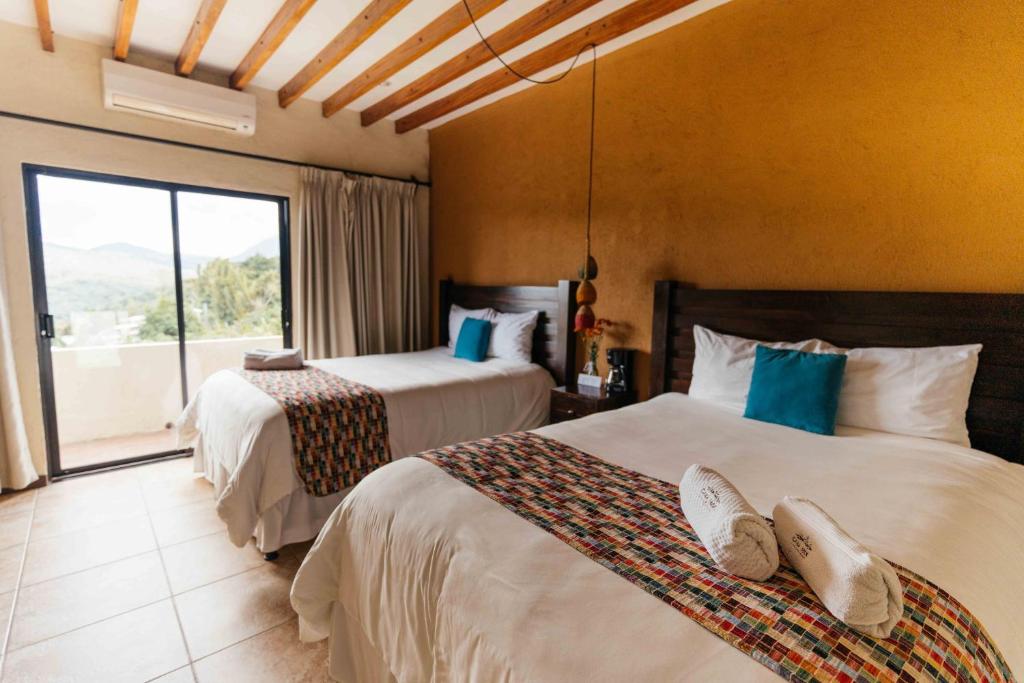 康塞普西翁德阿塔科Casa 1800 Ataco Hotel Boutique的酒店客房设有两张床和大窗户。