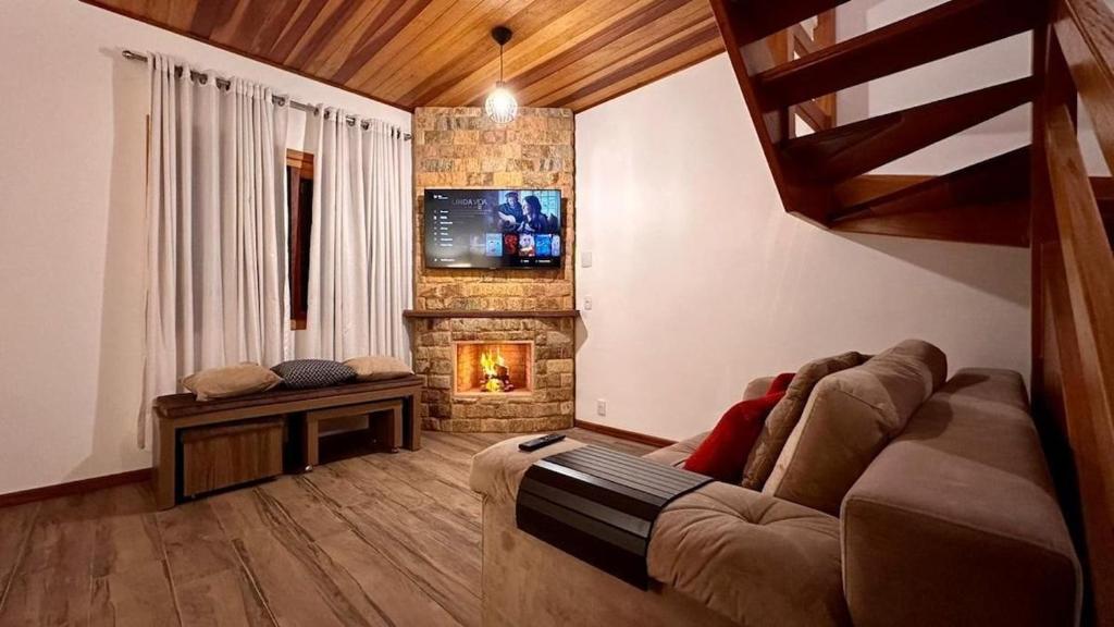 蒙特韦尔迪Chales Campestre Monte Verde - 150 mts do Centro的带沙发和壁炉的客厅