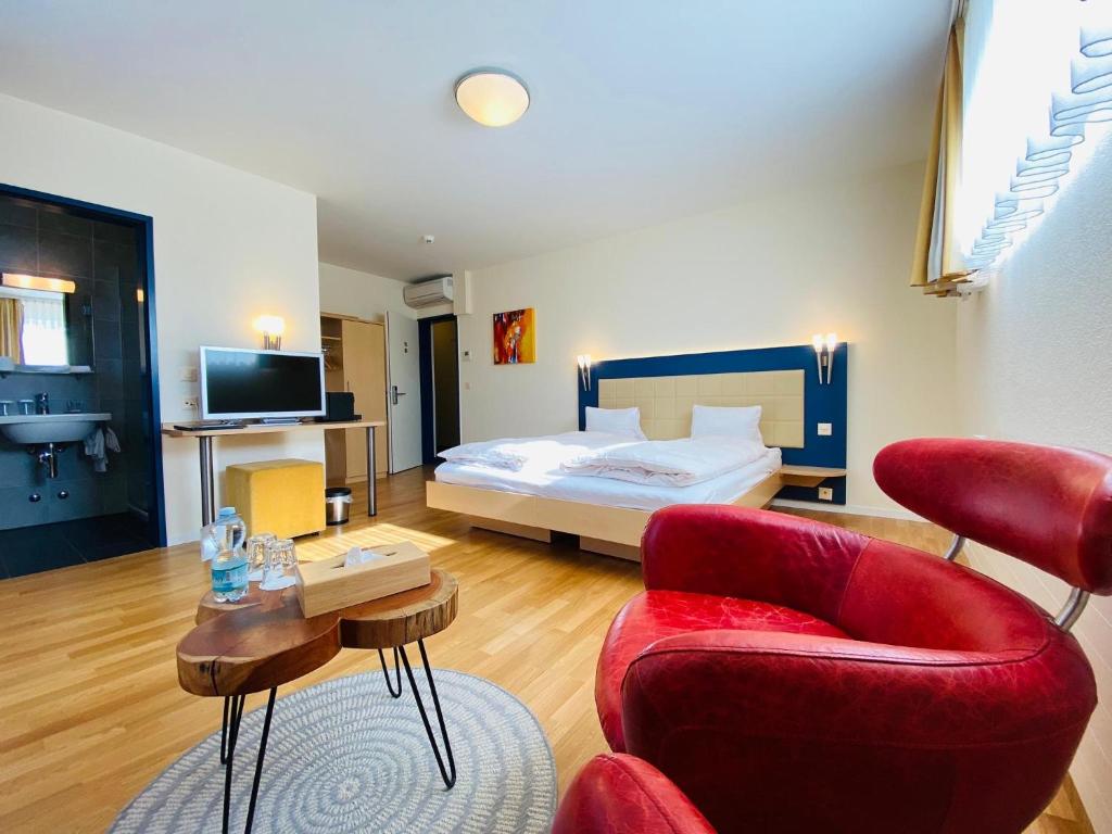 卢塞恩Vinum at Felmis SELF CHECK-IN的酒店客房配有一张床、一张沙发和椅子。