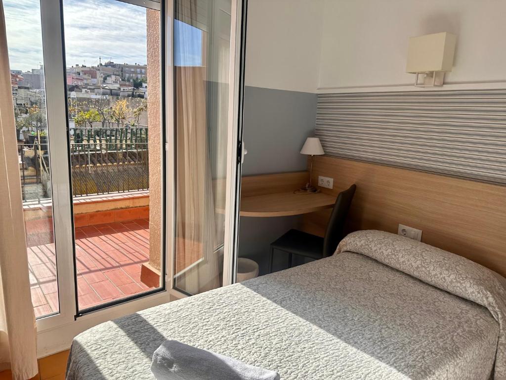 布拉内斯Can Setmanes by CozyCatalonia的一间卧室设有一张床,享有阳台的景色