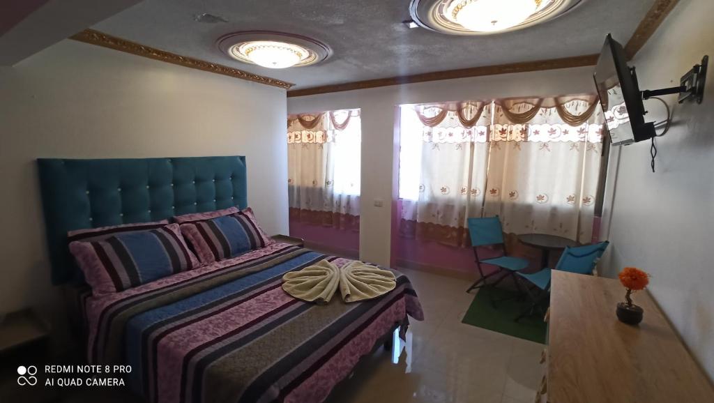 Alto HospicioHotel la Pampa的卧室配有一张床和一张桌子及椅子