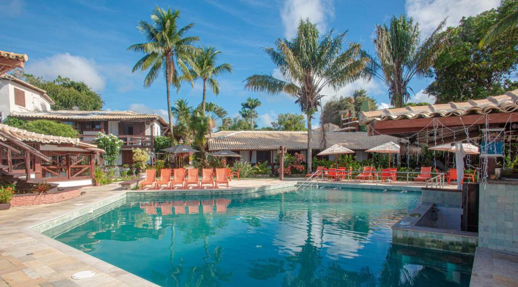 塞古罗港索拉杜伊姆佩拉多酒店 的一个带椅子和棕榈树的度假村游泳池