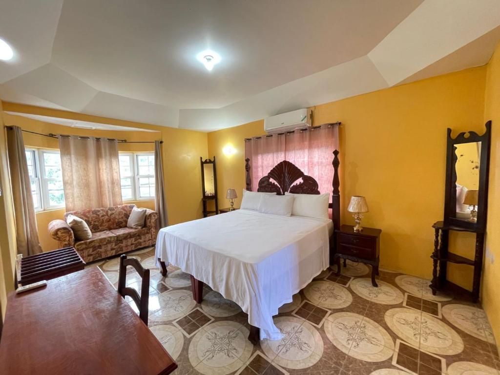 卢西Veronica Homestay Lucea Jamaica的卧室配有白色的床和沙发