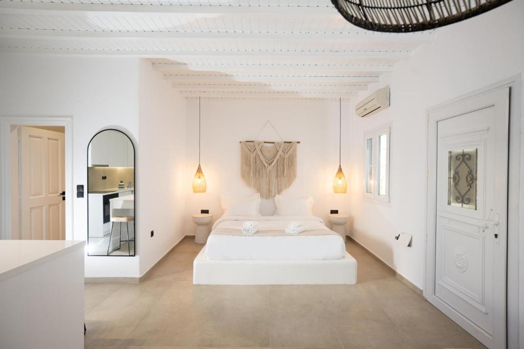 米克诺斯城Loom Suite Ornos的白色卧室配有床和镜子