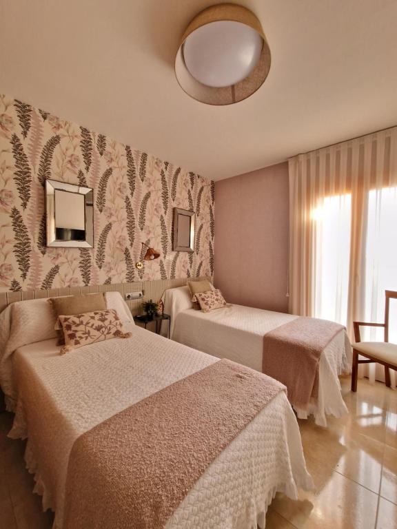 Castejón de MonegrosApartahotel La Chipranera的酒店客房,设有两张床和镜子