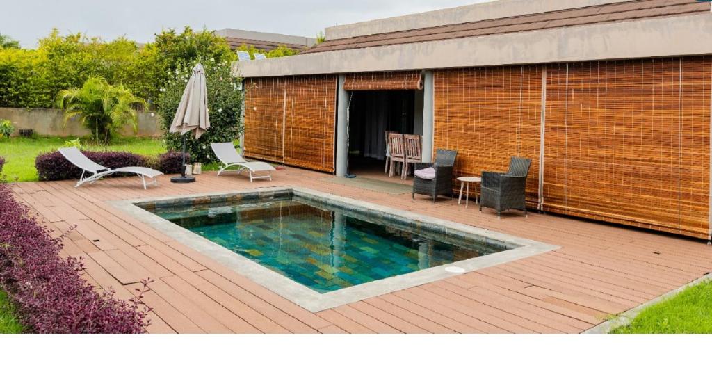 格兰贝伊Grand Bay Luxury Villa with Pool & Garden的一座位于大楼旁的木甲板上的游泳池