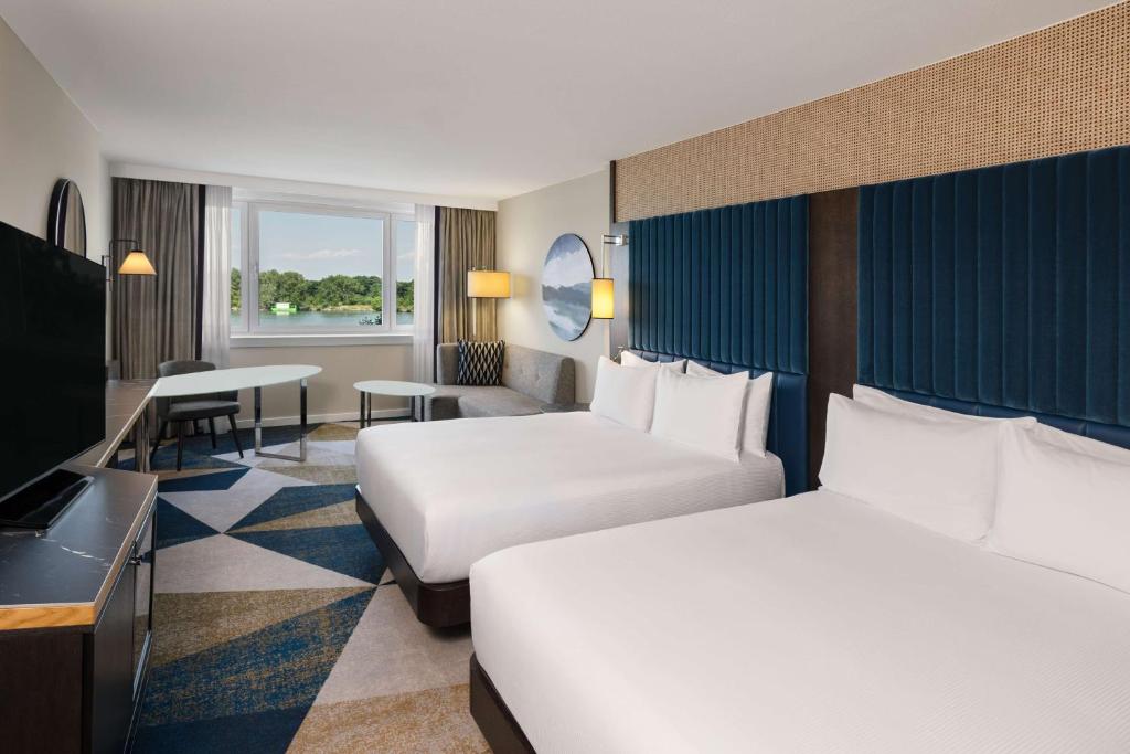 维也纳Hilton Vienna Waterfront的酒店客房配有两张床和一张书桌